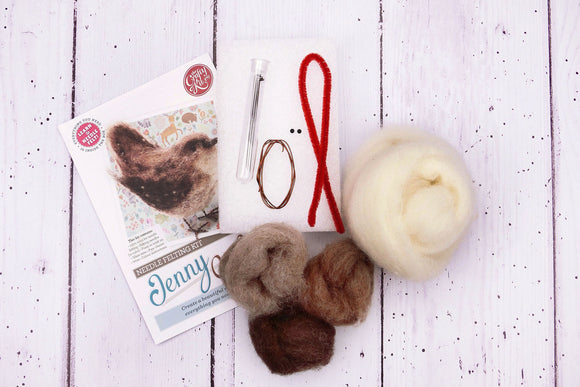 Knitting supplies including yarn, needles, and a pattern book on a wooden surface