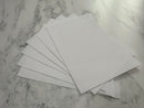 Stack of white envelopes on a marble surface