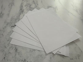 Stack of white envelopes on a marble surface