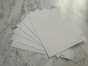 Stack of white envelopes on a marble surface