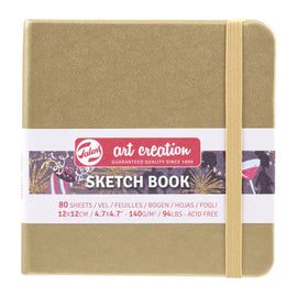 Sketch book with a gold cover and white label on a white background