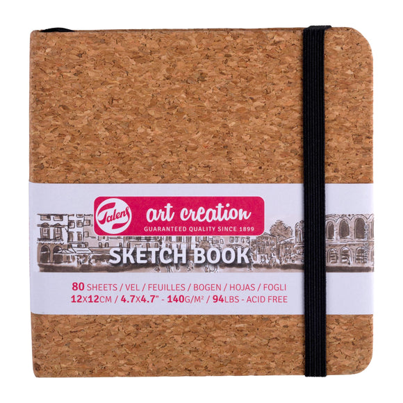 Cork sketchbook with black elastic band on a white background