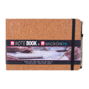 Cork-bound notebook with a black strap and Sakura branding on a white background