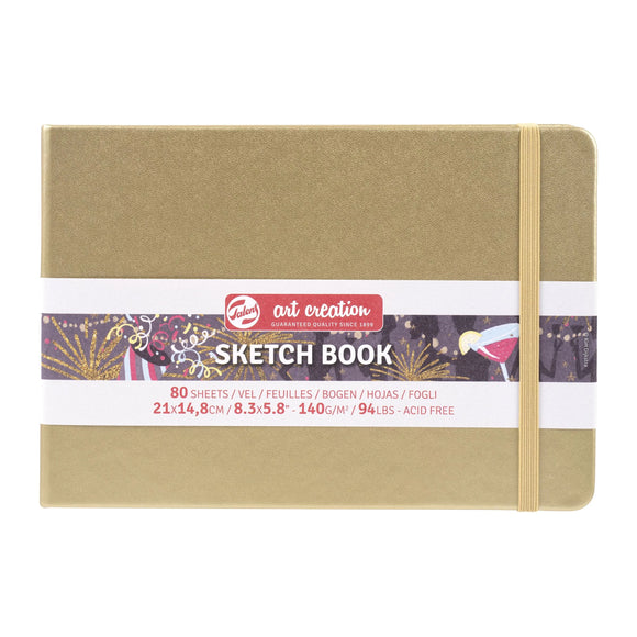 Sketch book with a gold cover and visible brand label on a white background