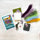 Artistic craft kit with felt pieces, card, and tools on a white surface