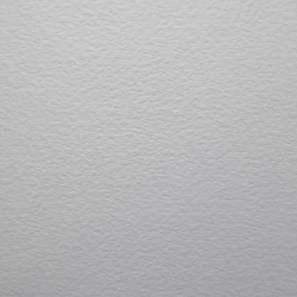 A close-up of a white textured surface, zeta card