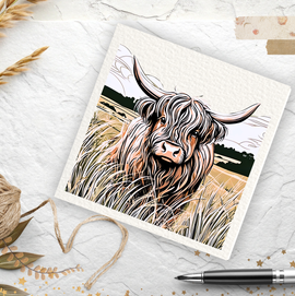 Card with a highland cow illustration on a textured surface with twine and pen.