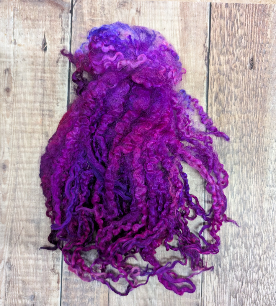 Beautifully hand-dyed curly locks in a bright, vibrant violet colour