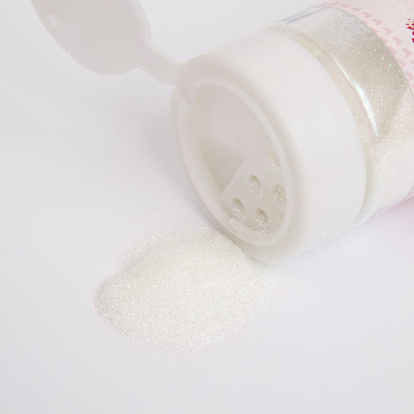 Bottle of glitter with spilled contents on a white background