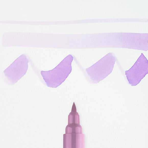 Pink marker with purple paint strokes on a light purple background