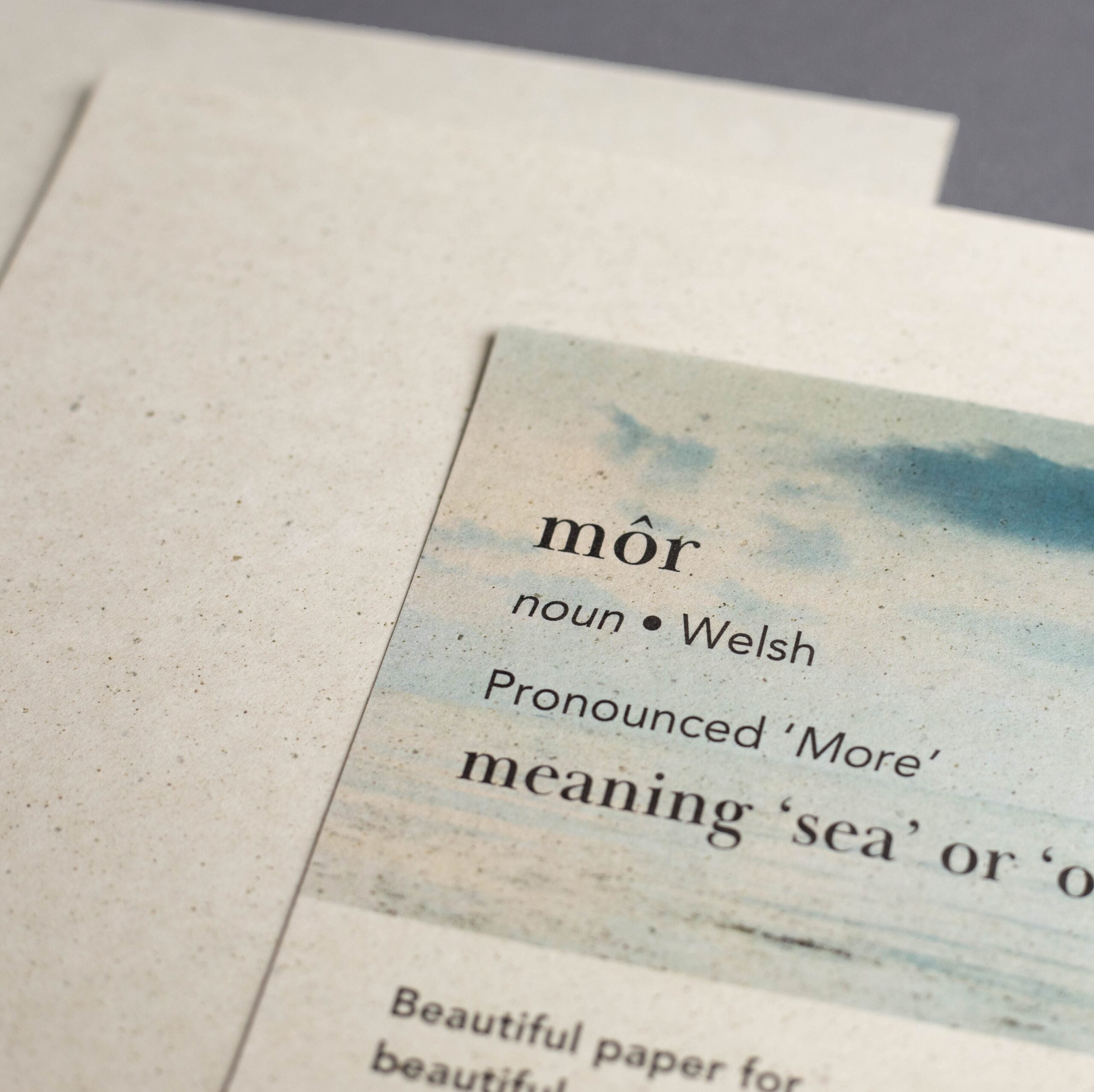 Card with Welsh word 'mör' definition and watercolor design on textured paper.